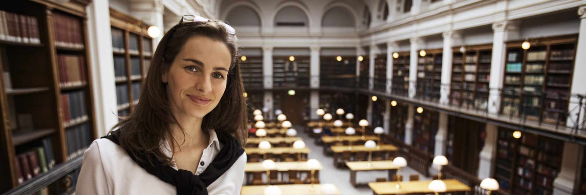 Friendly student reading in library upstairs.